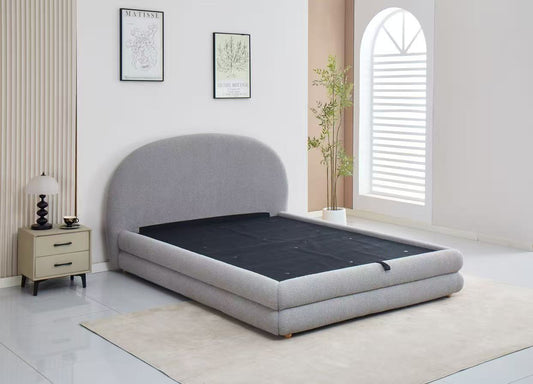 Gray upholstered bed in a room with a nightstand and decor